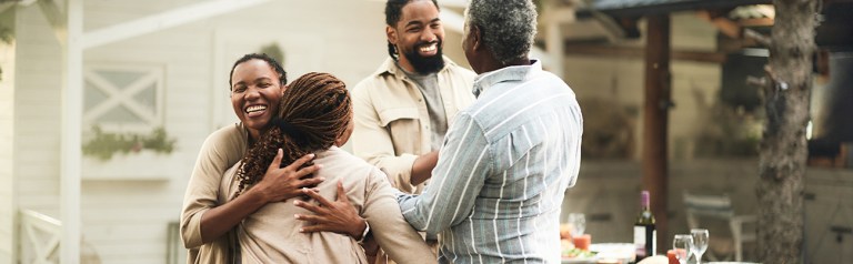 two couples at a backyard dinner party a home embracing as they successfully end their search to find a mentor couple